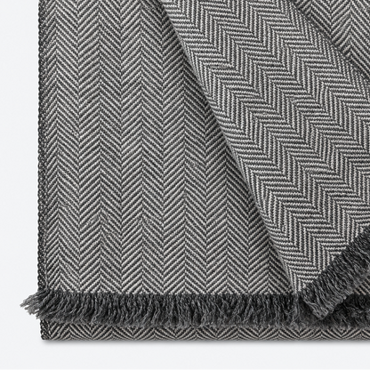 Gray herringbone scarf folded with fringe and contrasting weave