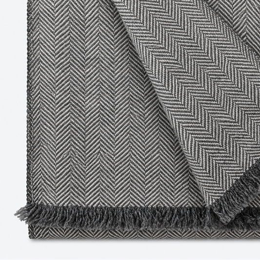 Gray herringbone scarf folded with fringe and contrasting weave