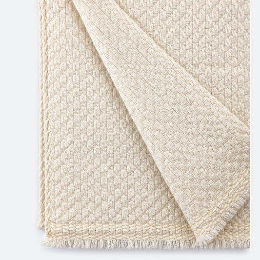 Close-up of ivory woven texture and fringed edge